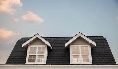 garret house with roof shingle in the evening time. wooden garret house and shingle tiles in the sunset.