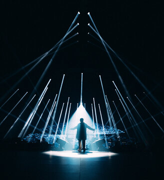 homme silhouette avec jeux de lumières pour un concert de musique dans une salle en festival de nuit