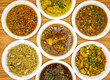 Assorted indian and pakistani spicy food chicken korma, daal mash fry, aloo matar qeema, gobhi gosht, aloo palak and gur chawal served in plate isolated on table top view
