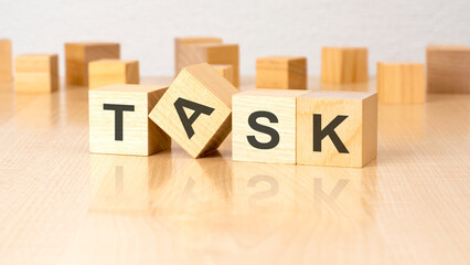 Sticker - four wooden blocks with text TASK on table. copy space. white background.