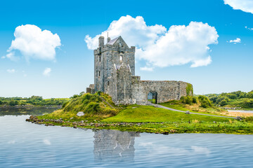 Wall Mural - Dunguaire castle on the seashore with reflection on calm sea water during sunny day, Dunguaire, Ireland