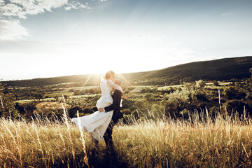 Wall Mural - The bride and groom hold hands and look to the future in the middle of nature, the newlyweds walk together,wedding photography,until death do us part