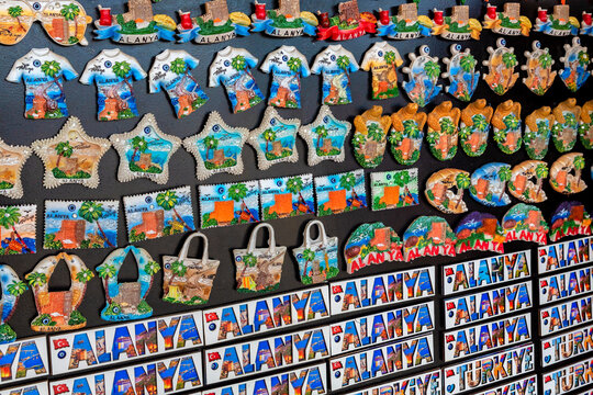 Alanya, Turkey - Aug, 6, 2022: Souvenir shop. There are many magnets for the refrigerator in the display case. Words Alanya and Turliye (Turkey) as marnets. Close up fragment, selected focus