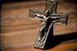idea of a Christian. Jesus Christ black cross in close up on an ancient wooden table. Generative AI