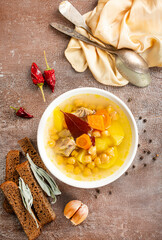 Canvas Print - Hot spicy soup with chickpeas, onions in ceramic bowl on a dark background close-up.