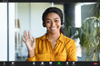 © Prostock-studio - Positive african american businesswoman making video call from office, waving hand at camera and smiling, pov screenshot