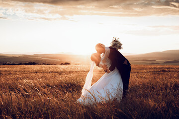 The bride and groom hold hands and look to the future in the middle of nature, the newlyweds walk together,wedding photography,until death do us part