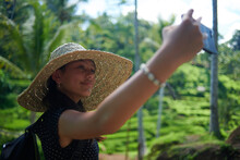 Teen Girl Wearing A Big Straw Hat Taking Selfies Using Mobile Phone
