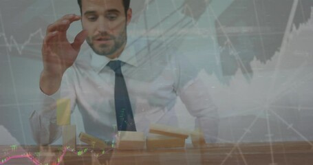 Poster - Animation of graphs and numbers over caucasian businessman playing with toy blocks falling on table