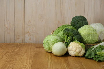 Poster - Many different types of fresh cabbage on wooden table. Space for text