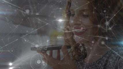 Poster - Animation of connected dots with lines and lens flares on caucasian woman talking on smartphone