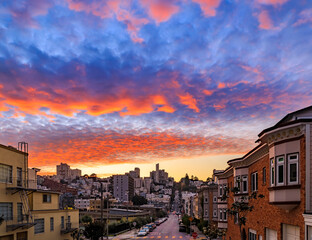 Wall Mural - High angle view of homes on the famous crooked Lombard Street, San Francisco California with fiery skies at sunset