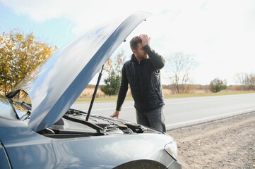 Wall Mural - A young man with a black car that broke down on the road,copy space.