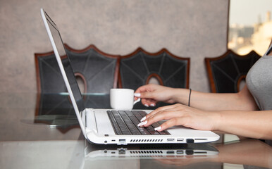 Wall Mural - Woman using white laptop computer at home.