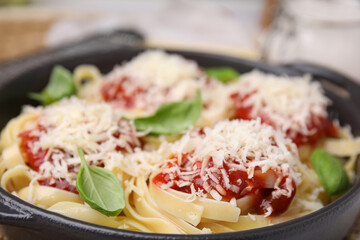 delicious pasta with tomato sauce, basil and parmesan cheese in bowl, closeup