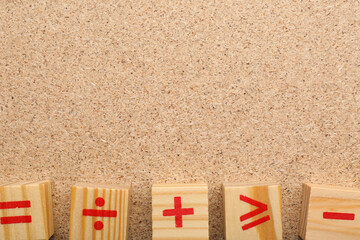Wooden cubes with mathematical symbols on fiberboard, flat lay. Space for text