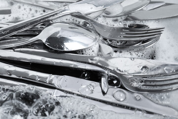 Sticker - Washing silver spoons, forks and knives in foam, closeup