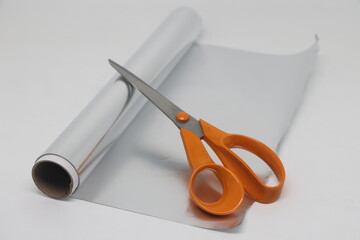 Metal food foil cut into strips and scissors. For sharpening scissors in everyday life.