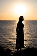 © Cavan Images - silhouette of woman by sunny and sea