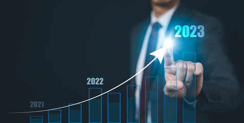 Wall Mural - Businessman touch growth data chart arrow with diagram 2023 budget, Businessman pointing arrow graph corporate future growth year 2022 to 2023, Development to success and motivation.