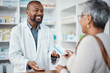 © C Daniels/peopleimages.com - Healthcare, pharmacist and woman at counter with medicine or prescription drugs in hands at drug store. Health, wellness and medical insurance, man and customer at pharmacy for advice and pills.