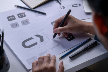 Graphic designer drawing sketches logo design. The concept of a new brand. Professional creative occupation with idea.