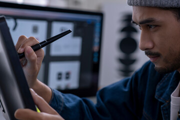 Asian male graphic designer working on computer drawing sketches logo design. The concept of a new brand. Professional creative occupation with idea.