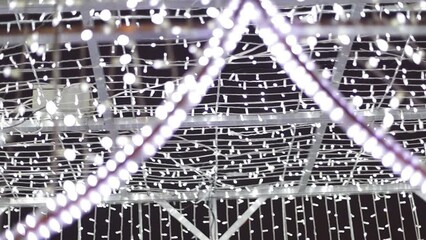Poster - a white garland on the street of the city. Christmas decoration
