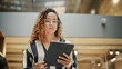 © Gorodenkoff - Portrait of a Powerful Female Leader Checking Meeting Briefing on her Tablet and Walking in Busy Corporate Office. Confident Hispanic Team Leader Preparing for a Presentation. Low Angle Shot