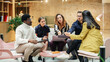 © Gorodenkoff - Group of Multiethnic Young People Strategizing in a Conference Room at Office. Female Supervisor Consulting her Team and Collectively Working on an Inclusivity Project. Close up