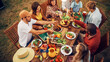 © Gorodenkoff - Top Down Elevated View at a Family and Friends Celebrating Outside at Home. Diverse Group of Children, Adults and Seniors Sitting at a Table, Having Fun Conversations. Eating Barbecue and Vegetables.
