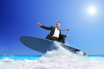 Businessman riding a surfboard on a sea wave