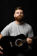 © Volodymyr - Portraite of handsome stylish bearded men with a acoustic guitar on a white background. Music performer musician. Musical string instrument.
