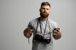 © Volodymyr - Portrait of bearded photographer with a bunch of different vintage old film cameras. Close up portrait of man holding vintage camera. Film photography.