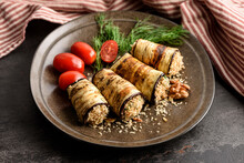 Grilled Eggplant Rolls Stuffed With Walnuts On A Plate With Tomatoes And Fresh Green Dill.