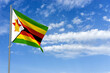 Republic of Zimbabwe Flag Over Blue Sky Background. 3D Illustration