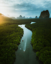 Aerial View Of A Boat Sailing The River Across Phang Nga Bay At Sunrise In Thailand.