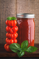 Sticker - Jar of home canned tomato sauce and stack of costoluto genovese tomatoes topped with basil leaves