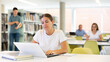 © JackF - Young female European student studying with a laptop in the library