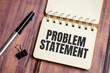 problem statement words on notebook with pen and clips