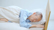 © taka - ベッドで睡眠中の高齢者