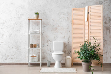 Poster - Interior of restroom with toilet bowl, shelving unit and folding screen