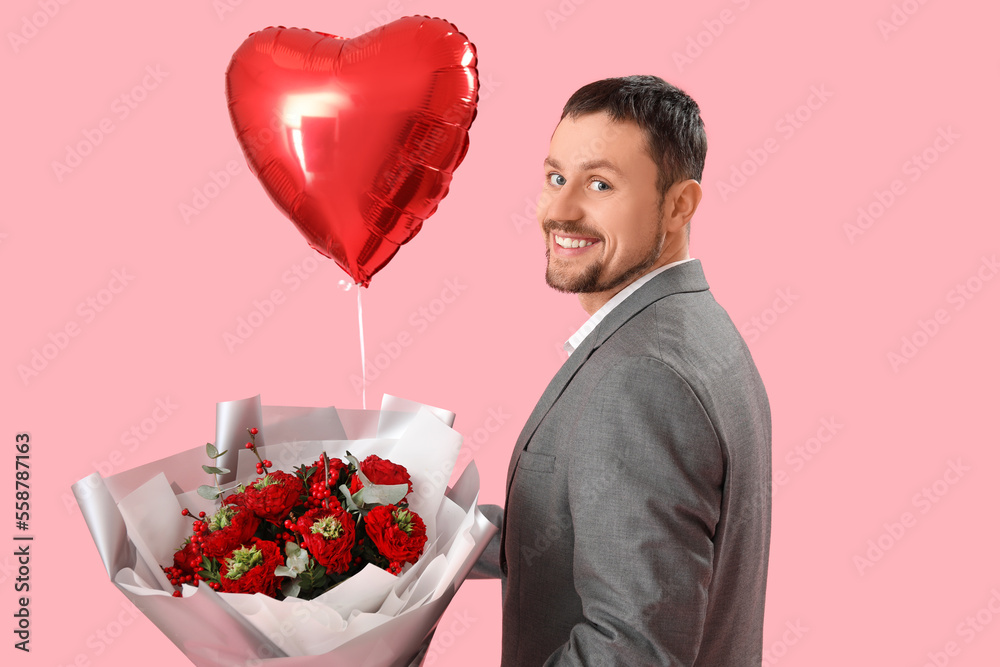 Handsome man with heart-shaped balloon and flowers on pink background. Valentine's Day celebration