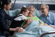 © DC Studio - Happy little girl greeting sick grandmother with hug on hospital room visit. Old lady lying on medical bed happily giving hugs to granddaughter at geriatric patients medical clinic.