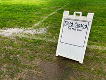 Field Closed Do Not Use Sign On Green Lawn At A Public Park Due To Weather Conditions