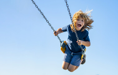 swinging on playground. funny kid on swing. little boy swinging on playground. happy cute excited ch