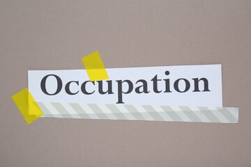 Word Occupation attached with yellow adhesive tape on grey background