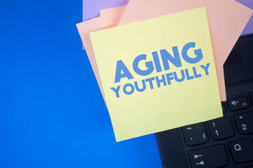 Poster - Aging Youthfully. Text on adhesive note paper. Event, celebration reminder message.