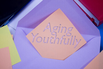 Poster - Aging Youthfully. Text on adhesive note paper. Event, celebration reminder message.