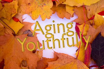 Poster - Autumn leaves, objects with Aging Youthfully text. Natural patterns, color design.